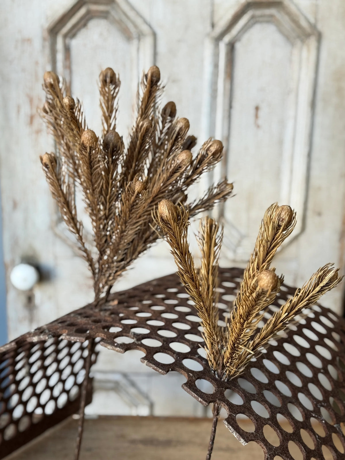 Decorative gold branches on a metal surface with a neutral background