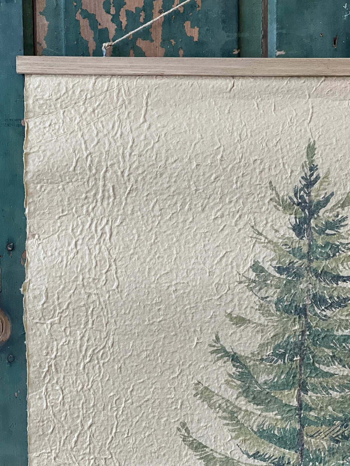 Close up image of a textured white paper print with a green tree design on a blue background