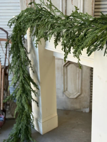 Green garland draped over a fireplace mantle