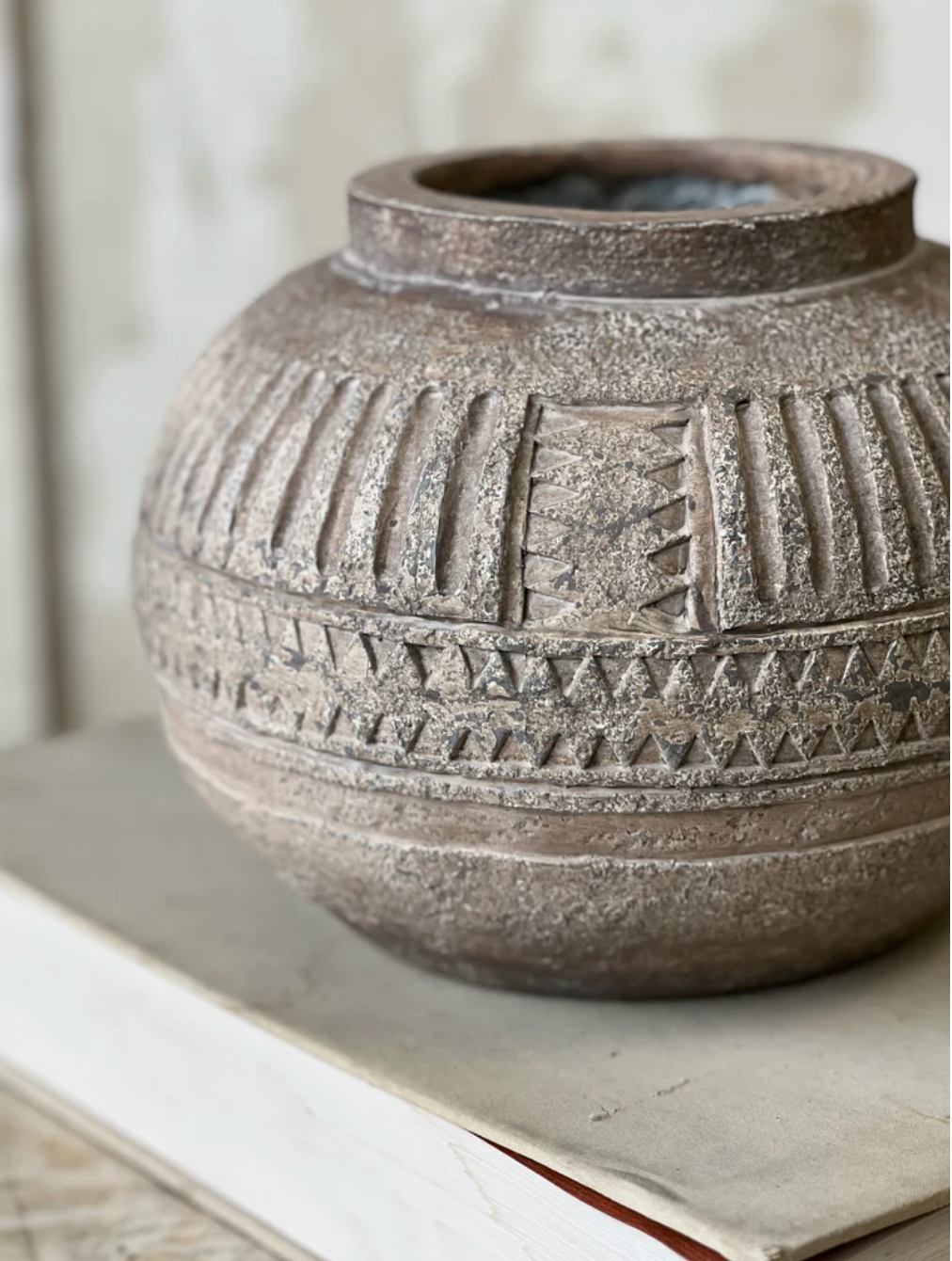 Textured ceramic vase with geometric patterns on a neutral background