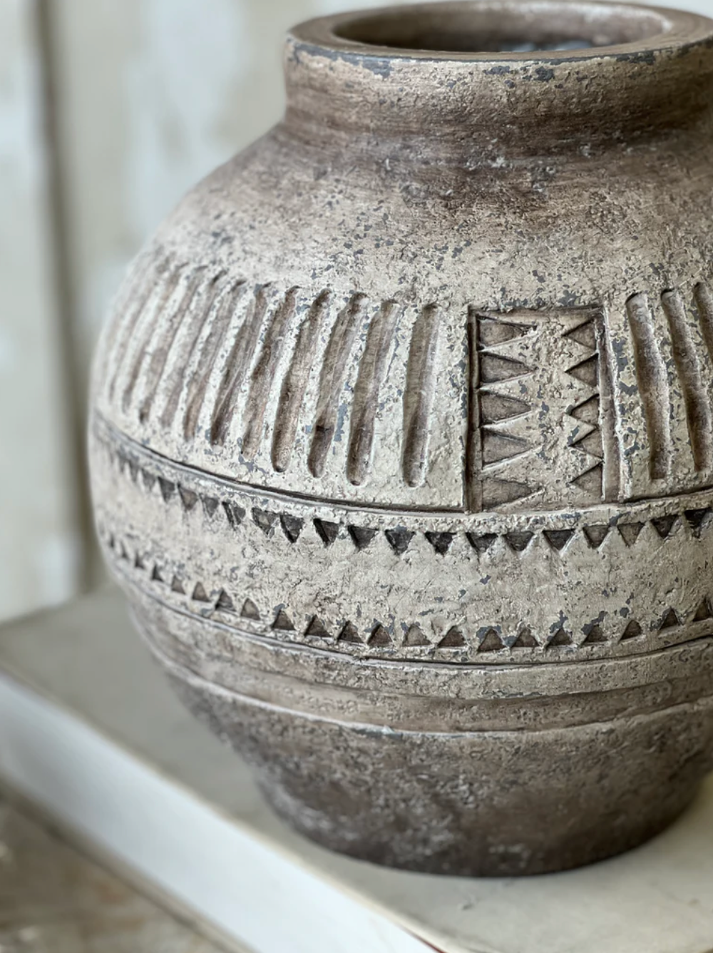 Decorative ceramic jar with geometric patterns on a white surface