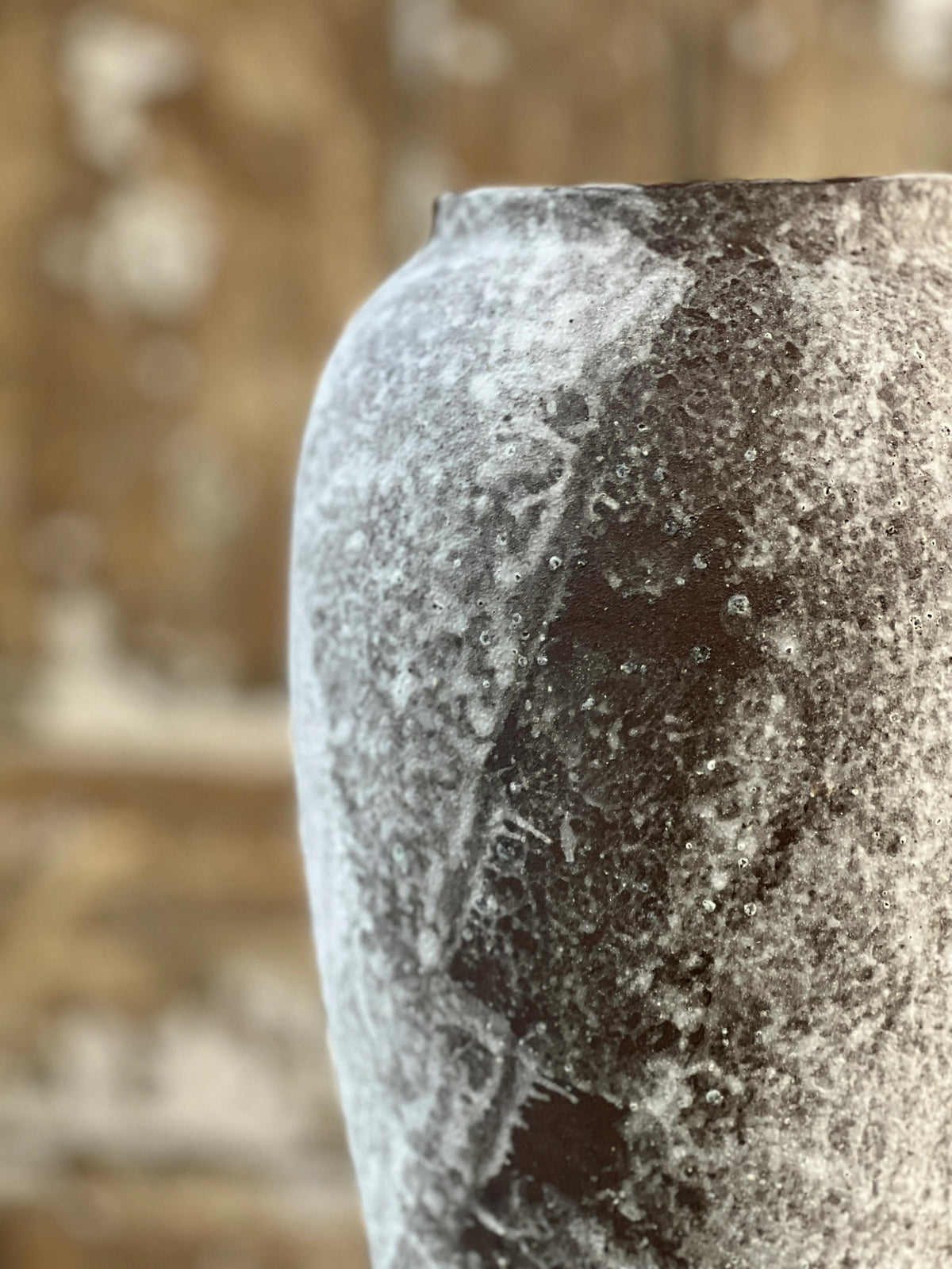 Close-up of a textured stone vase with a blurred background