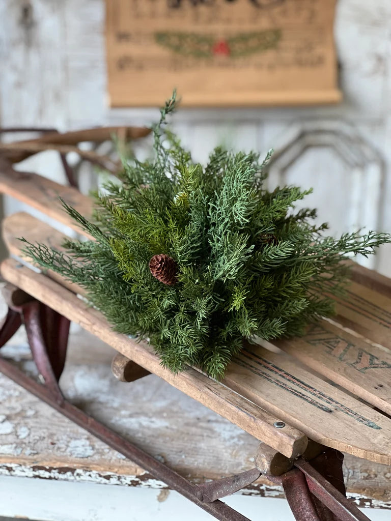 Close up of evergreen greenery half sphere on an old wooden sled with a rustic background