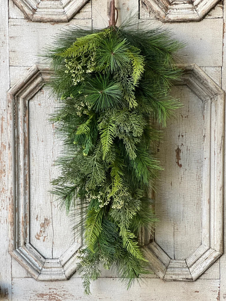 Green wreath hanging on a rustic wooden door